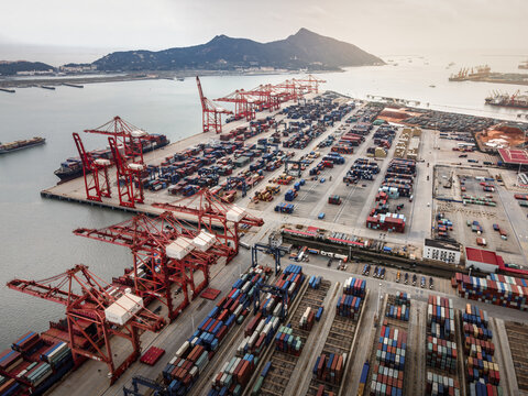 Busy Commercial Container Port With Cranes And Ships
