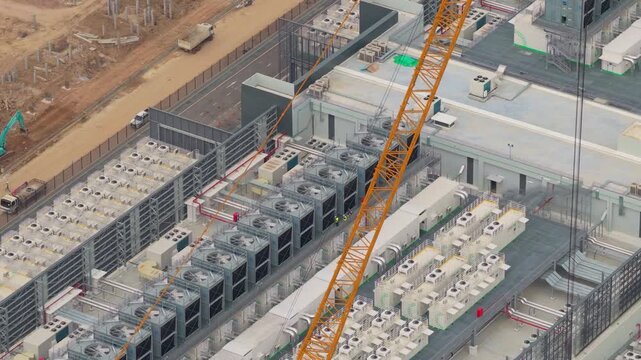 High angle view showcasing a hyperscale data center during its construction phase. The footage highlights the cooling systems and cranes