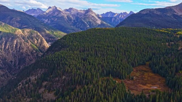 Panoramic aerial sunset illuminates rugged Needles peaks viewed from Molas Overlook along the Million Dollar Highway in Colorado
