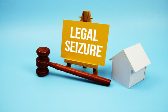 Legal Seizure text with judgment gavel and house model on blue background