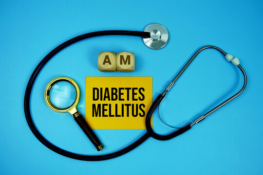 Diabetes Mellitus (DM) text with stethoscope and magnifying glass on blue background