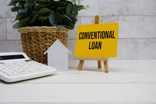 Conventional Loan text with house model and calculator on wooden background