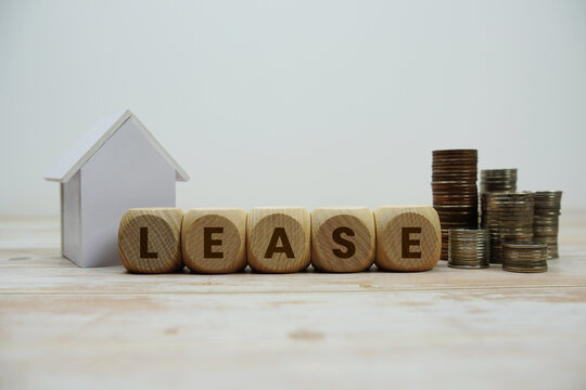 LEASE alphabet letters with house model and coin stack Properties and Real Estate Concept