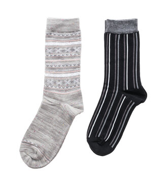 Two different patterned new socks grey knit and black striped isolated on black background