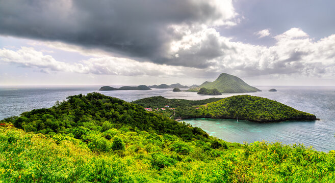High angle panoramic view over lush green hills, turquoise ocean waters, and neighboring islands in Terre-de-Bas, les Saintes, Guadeloupe.