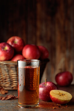 Apple juice with apples on an old kitchen table.