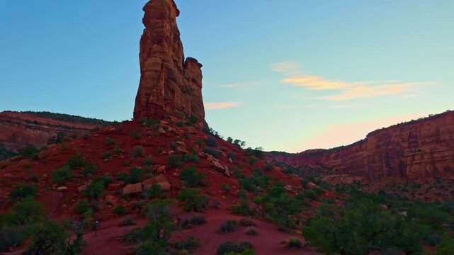 Warm sunset light illuminates Independence Monument and towering sandstone formations along Monument Canyon Loop Trail in Colorado