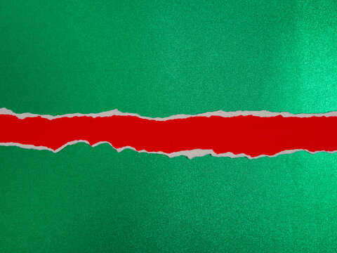 Torn Red Paper Strip on a Green Background with Christmas Copy Space