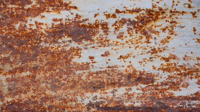 Weathered metal surface with heavy rust texture and peeling paint