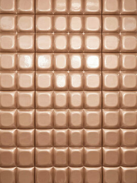 Abstract background of glossy rose gold square tiles