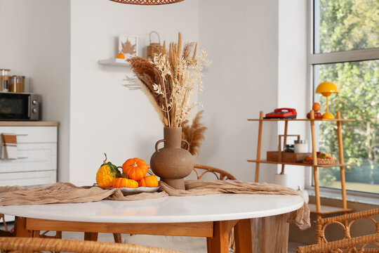 Autumn home decor and seasonal interior design, dried flowers in vase with pumpkins on dining table for thanksgiving holiday and harvest celebration