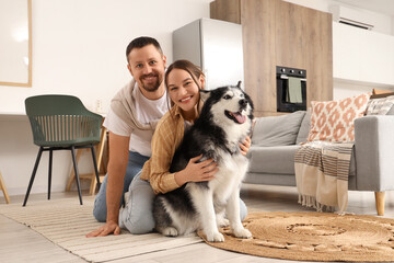 Pet ownership and domestic happiness, happy couple sitting on floor with husky dog in modern living room interior for lifestyle and family © Pixel-Shot
