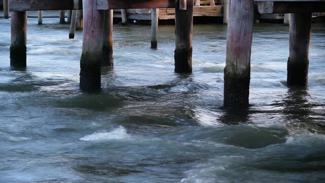 古い川舟乗り場の木柱を巡る流れ シームレスループ動画背景 16:9 4K