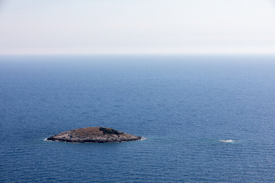 A tiny island surrounded by the crystal-clear waters of the Mediterranean sea, offering a peaceful and picturesque coastal landscape.