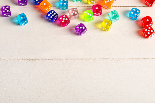 Colorful game dices on white wooden background