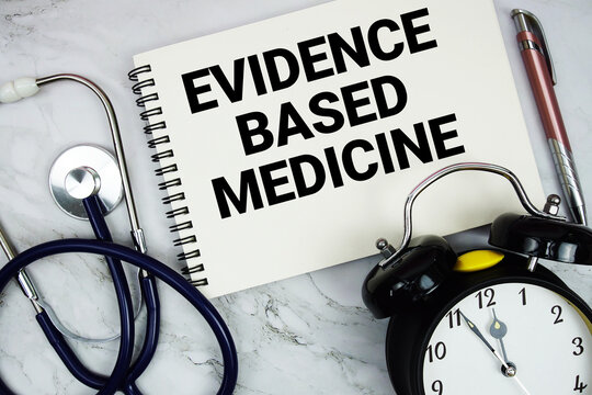 Evidence Based Medicine text written on notepad with stethoscope and alarm clock on marble background