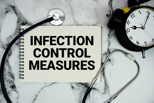 Infection Control Measures text written on notepad with stethoscope and alarm clock on marble background