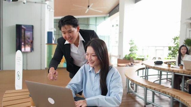Asian Business Colleagues Celebrating Success with Laptop in Bright Office Canteen