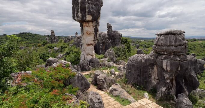 Tilt up shot starts with closeup of natural weathered heart shape hollow in karst limestone boulder before revealing massive 15-meter Wannian Lingzhi mushroom rock.