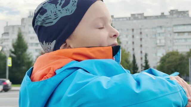 A young boy leans on a stone ledge and gazes with curious joy. He looks out over a street in Saint Petersburg with a calm heart. The moment feels peaceful.