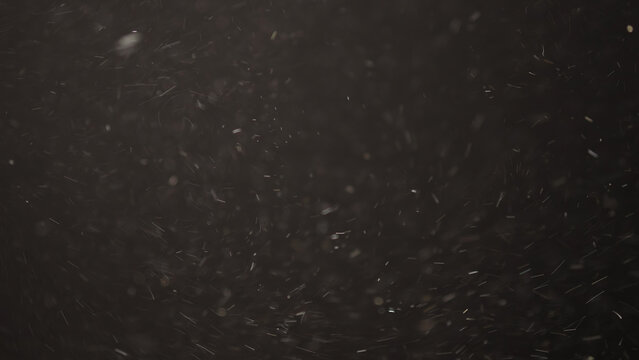 Slow motion real dust flow over dark background