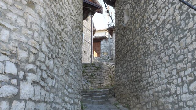 First person perspective view of a narrow alley with ancient stone walls in the old town of Berat, Albania, an Unesco world heritage site