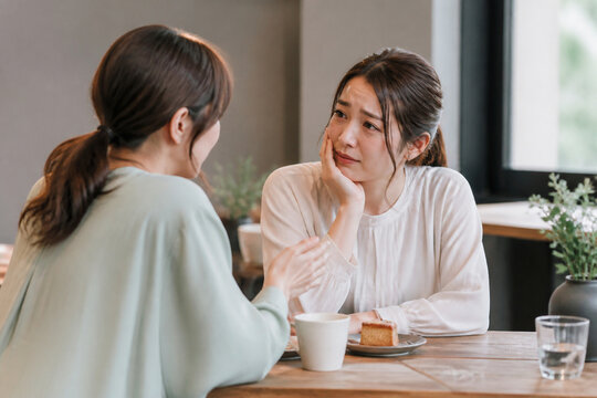カフェで悩みを相談する30代女性の友人同士