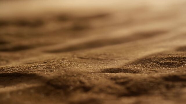 Softly moving sand texture fills an earthy brown close-up with shallow focus. Environmental title, nature documentary transitions, and earthy product advertising.