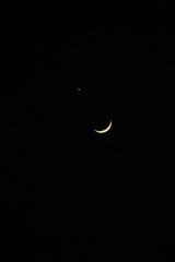 The bright planet Venus and a slender crescent Moon, visible in the twilight sky on September 14, 2026. A brilliant point of light resembling a star sits directly above the lunar crescent. © Joshua Prasetyadi