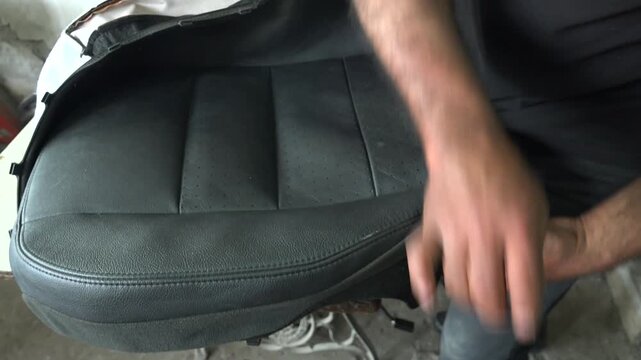 Black leather seat cover installation shows stitched upholstery texture clean automotive interior.