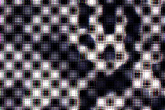 Retro halftone pattern texture consists of chaotic raster dots on a gray backdrop. Distressed