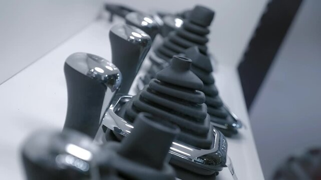 Samples of new automotive gearshift levers with rubber casing are on display at the exhibition. Closeup. Shot in motion. Follow focus