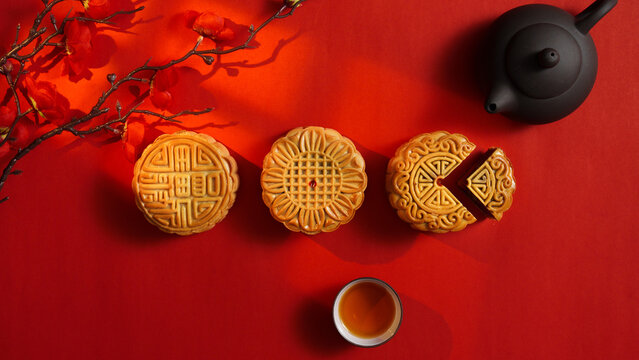 Mooncakes and tea set on red background for Mid Autumn Festival