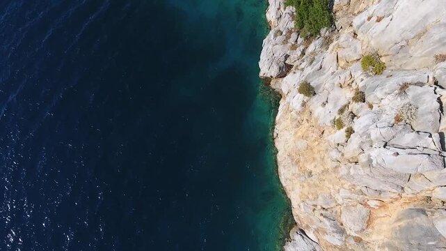 Aerial drone view of rugged sea cliffs and steep rocky coast with untouched natural terrain.