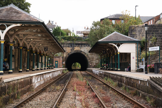 Historic knaresborough railway station platforms and tracks converging into a dark tunnel, creating a sense of journey, connection, and anticipation for future travel in yorkshire, england
