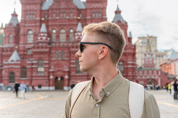 Profile portrait of a young male tourist in sunglasses against the State Historical Museum in Moscow © KseniaJoyg