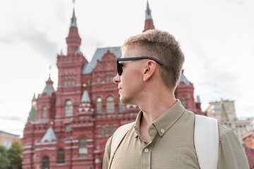 Profile portrait of a young male tourist in sunglasses against the State Historical Museum in Moscow © KseniaJoyg