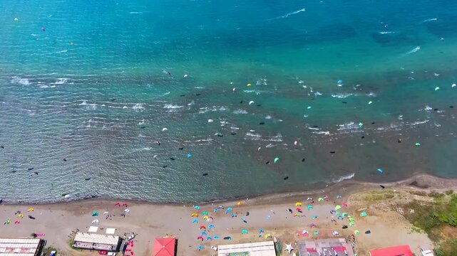 Aerial drone view of kiteboarders in Akyaka Gokova Bay Turkey with wind, waves, and beach.