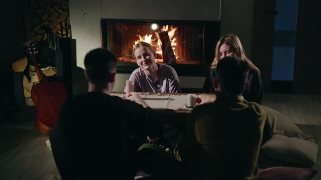 Friends Gather Around Table by Fireplace