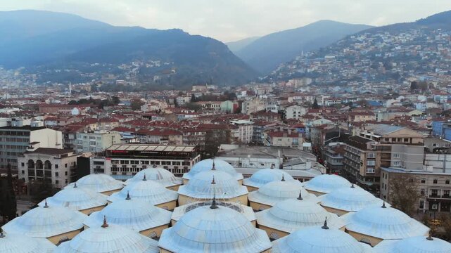 Aerial drone view of Bursa Ulu Mosque in Turkey with domes, minarets, and Ottoman form.