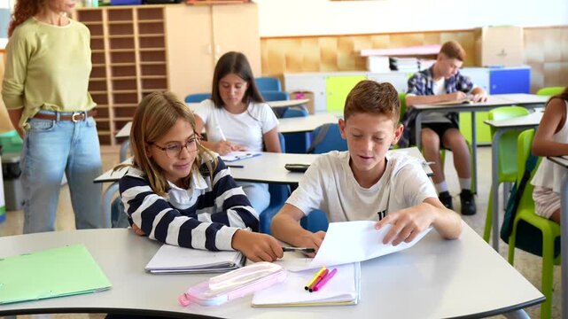 Young students working together in pairs on a collaborative assignment during a lesson. With a teacher supervising in the background. Promoting teamwork and active learning in an educational setting