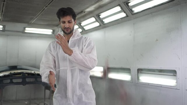 Mechanic Examining Blue Car Bumper In Auto Body Repair Shop