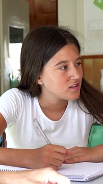 Young female student feeling confused and frustrated while studying at home, gesturing with her hands and making faces as she tries to understand a difficult school assignment with a tutor