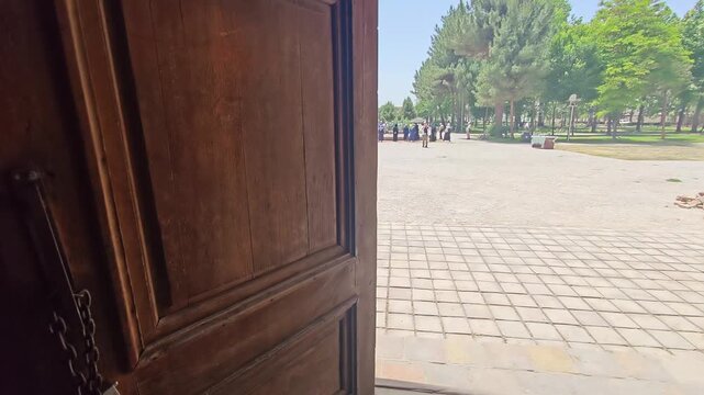 Old wooden door at Haruniyeh Dome shows weathered craftsmanship in a historic Iranian monument.