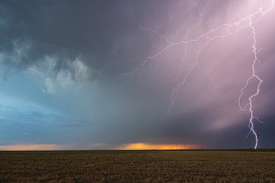 Lightning striking Storm-covered field at sunset in ulysses, kansas