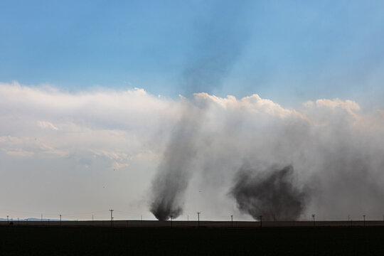 Twin tornadoes lifting dust at county road 2 in fowler colorado