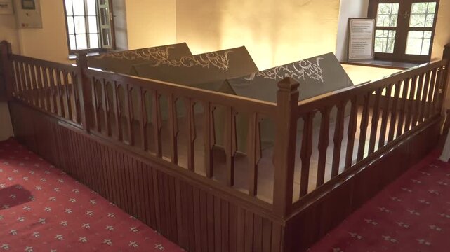 Cloth covered caskets rest inside Islamic tomb, sacred interior reflecting spiritual mourning.