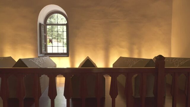 Cloth covered caskets rest inside Islamic tomb, sacred interior reflecting spiritual mourning.