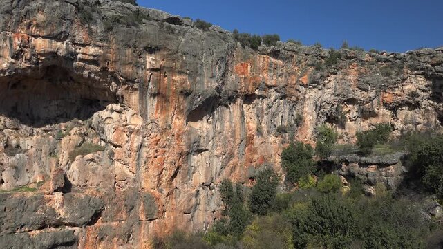 Large karst sinkhole reveals rocky walls deep depression with limestone geology rugged terrain.