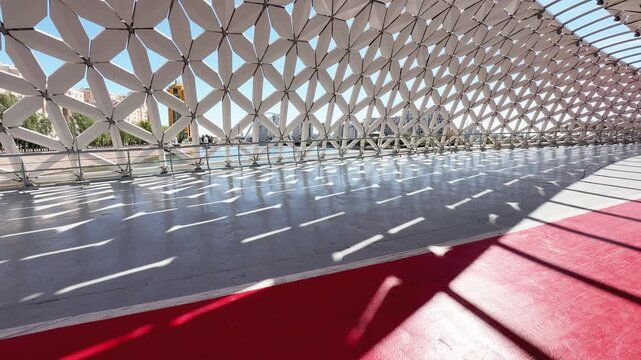 Atyrau Bridge in Astana, featuring curved white canopy, geometric metal panels, red pathway and modern architectural design, Kazakhstan, shot handheld, 4k footage